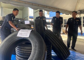 WAN Mohd. Zahari Wan Busu (dua dari kiri) menunjukkan tayar lori yang dirampas susulan tertumpasnya Geng Vennu. - UTUSAN/NORHAFIZAN ZULKIFLI