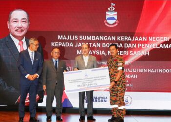 HAJIJI Noor menyampaikan sumbangan peruntukan kepada Pengarah JBPM Sabah, Abdul Razak Muda (kanan) di Kota Kinabalu, hari ini.