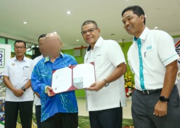 SAIFUDDIN Nasution Ismail (tengah) menyerahkan penggantian kad pengenalan ketika melawat ke Rumah Seri Kenangan, Ulu Kinta di Ipoh hari ini. - UTUSAN/MUHAMAD NAZREEN SYAH MUSTHAFA