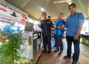 SHARUDIN Hamid (kiri) menunjukkan mesin digunakan untuk memproses sisa makanan yang dikumpul menjadi baja yang ditempatkan di Padang MBK 1, Kuantan.  UTUSAN/NORHAFIZAN ZULKIFLI