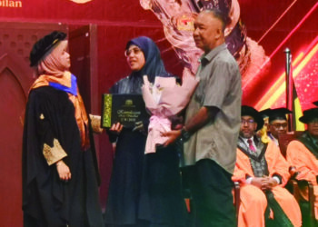 FADHLINA Sidek menyampaikan skrol Diploma Kosmetologi Nur Adlina Nabilah kepada Anuar Ahmad (kanan) dan Aminah Sahadan pada Majlis Konvokesyen Kolej Vokasional Kementerian Pendidikan Malaysia di Nilai, semalam. – UTUSAN/NUR SHARIEZA ISMAIL