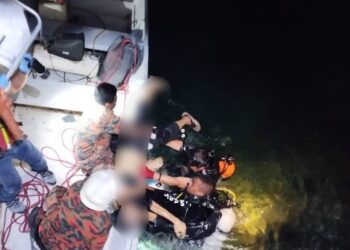 PASUKAN bomba mengeluarkan mangsa daripada kenderaan yang terjunam ke dalam laut di Kampung Payang, Lahad Datu, Sabah, semalam. - IHSAN BOMBA