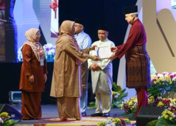 SULTAN Nazrin Muizzuddin Shah menyampaikan hadiah johan qari kepada Puteri Kalimatul Azzua Hamid pada Majlis Tilawah dan Hafazan al-Quran peringkat negeri di Ipoh. - UTUSAN/MUHAMAD NAZREEN SYAH MUSTHAFA