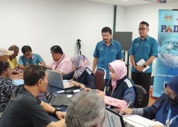 MOHD. Uzir Mahidin (berdiri, kiri) diiringi Mohd. Sawal Shakimon (berdiri, kanan) melihat aktiviti pendaftaran untuk PADU semasa melakukan lawatan di UTC Seremban di Ampanga, Seremban hari ini.-UTUSAN/NAZARUDIN SHAHARI.
