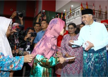 AHMAD  Zahid Hamidi (kanan) menyampaikan sumbangan kepada penerima pada Majlis Santunan Kasih Ramadan RISDA di Bagan Datuk hari ini. - UTUSAN/MUHAMAD NAZREEN SYAH MUSTHAFA