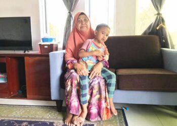 ZAWIYAH Sulaiman bersama salah seorang cucunya di Kampung Palas Merah, Tumpat, Kelantan - UTUSAN/ROSLIZA MOHAMED