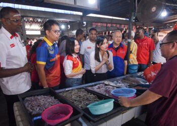 Calon-calon yang bertanding termasuk Pang Sock Tao daripada PH (tengah) menyantuni peniaga di Pasar Awam Kuala Kubu Baharu. - U TUSAN/M. FIRDAUS M. JOHARI