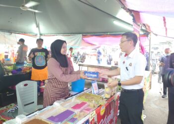 LEE Ting Han menyampaikan plak mengiktiraf peniaga yang menjual produk pada harga berpatutan di Bazar Ramadan Taman Perling, Johor Bahru.