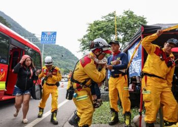 SEORANG wanita dan kanak-kanak keluar dari sebuah van di pos sementara selepas diselamatkan dari Taman Negara Taroko di Hualien.-AFP