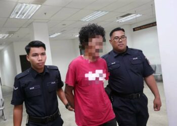 TERTUDUH (tengah) semasa dibawa ke Mahkamah Majistret Kota Bharu, Kelantan hari ini-UTUSAN/ROSALWANI CHE SOH.