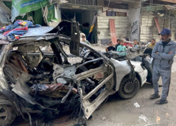 PENDUDUK Palestin melihat keadaan kereta dinaiki tiga anak Ismail Haniyeh yang musnah dibedil tentera Israel di kem al- Shati di Gaza City.-AFP