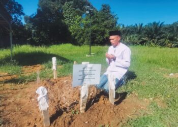 AZAM Radin Mustapha Amiruddin menziarahi kubur isteri dan tiga anaknya di Tanah Perkuburan Islam Pekan Bidor, Tapah, Perak, semalam. - UTUSAN/AIN SAFRE BIDIN