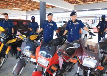 WAN Jamal Abdul Salam Wan Long (kanan) bersama pegawai memeriksa model motosikal jenis Yamaha RXZ yang diseludup dari Thailand di Unit Operasi Penguatkuasaan JKDM, Kota Bharu, Kelantan, semalam. - UTUSAN/KAMARUL BISMI KAMARUZMAN