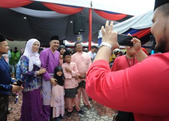 MOHD. Jafni Md. Syukor (tiga dari kiri) bergambar bersama tetamu sempena majlis rumah terbuka Hari Raya Aidilfitri di Bandar Putra, Kulai, Johor. - UTUSAN/RAJA JAAFAR ALI 