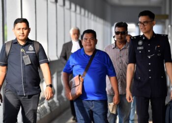 SAMSURI Ramli (berbaju biru) hadir di Mahkamah Sesyen Kuala Lumpur untuk menghadapi pendakwaan kes memulakan hantaran mengancam Yang di-Pertuan Agong. - UTUSAN/SHIDDIEQIIN ZON