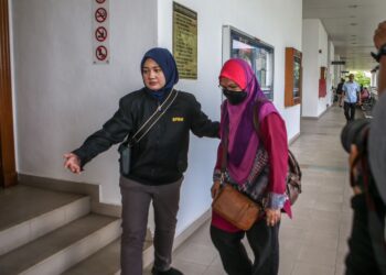 PEGAWAI SPRM membawa Fadziyani Mohamed yang berdepan pertuduhan menipu di Mahkamah Sesyen Alor Setar. -UTUSAN/SHAHIR NOORDIN