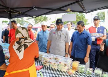 MOHD. Jafni Md. Shukor (tengah) menyantuni peniaga di Bazar Ramadan Jalan Enggang, Kulai, Johor.