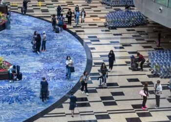 PENUMPANG berjalan melalui dewan transit berlepas di Lapangan Terbang Changi Singapura.-AGENSI