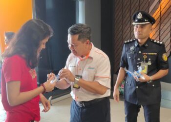 CHE Sulaiman Che Pa (tengah) mengagihkan biskut khas kepada penumpang sempena pencapaian Anugerah Lapangan Terbang Terbaik di Asia Pasifik di LTAL Langkawi, hari ini.