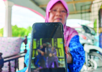 SITI HAJAR Hamid menunjukkan gambar Muhammad Nur Hadith sekeluarga semasa Hari Raya Aidilfitri baru-baru ini.