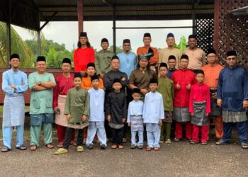 SHAHRIL Tukiman (berdiri dua dari kiri belakang) bergambar raya terakhir bersama Mohamad Amir Mohamad (paling kanan berbaju biru) dan rakan-rakan sekampung pada sambutan Hari Raya Aidilfitri di Felcra Bukit Kepong, Segamat baru-baru ini.