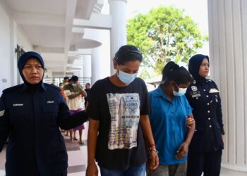 ANGGOTA polis membawa L. Vignesvari (dua kiri) bagi menghadapi pertuduhan kes pukul seorang warga emas di Mahkamah Majistret Kulim. -UTUSAN/ SHAHIR NOORDIN