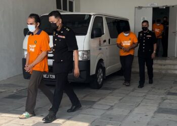 SUSPEK dibawa keluar selepas permohonan reman diluluskan bagi membolehkan siasatan dijalankan berhubung kes pemalsuan dokumen di Kompleks Mahkamah Kangar, Perlis hari ini.-UTUSAN/ASYRAF MUHAMMAD