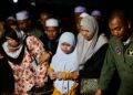 ANAK sulung arwah, Nur Sya Indah Aulia Mohamad Faisol (tengah) ditemani ibu saudaranya mengiringi jenazah bapanya yang dikebumikan di Tanah Perkuburan Islam Masjid Al-Muhtahdin di Sik Dalam, Sik. -UTUSAN/SHAHIR NOORDIN