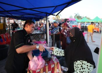 PENGUNJUNG mengambil kesempatan membeli ayam yang dijual murah pada program Agro Madani @ Peladang Outlet di Kuala Terengganu, semalam.  - UTUSAN/KAMALIZA KAMARUDDIN