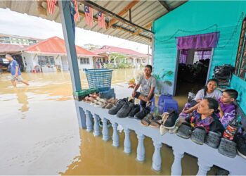 PENDUDUK di Jalan Bahagia, Meru, Klang, terpaksa duduk di luar selepas rumah mereka dilanda banjir kilant susulan hujan lebat, sejak petang kelmarin. – UTUSAN/SHIDDIEQIIN ZON