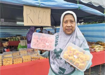 KHAIRRUNI Ahmad Zabidi menunjukkan biskut raya yang dijual pada harga RM6 sebekas di gerainya di Jalan Hospital, Ipoh.