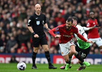 KAPTEN Manchester United Bruno Fernandes dikasari pemain Liverpool pada aksi Liga Perdana Inggeris di Stadium Old Trafford, sebentar tadi.-AFP