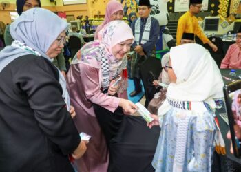 FADHLINA Sidek menyampaikan sumbangan duit raya kepada seorang kanak-kanak yang diraikan pada Majlis Iftar Si Burung Kecil dan Ramah Mesra bersama-sama Pengamal Media di Kompleks Seri Bintang, Kuala Lumpur, hari ini. - UTUSAN/MUHAMAD IQBAL ROSLI