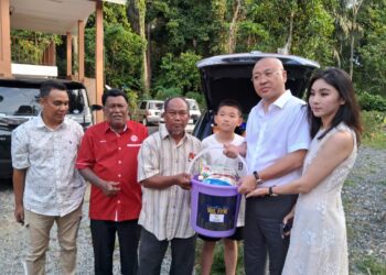 LI RUIDONG (dua kanan) menyampaikan bakul makanan dan duit raya kepada Mohd. Rozi Yaakob di Kampung Kedondong, Pulau Tawar di Jerantut, Pahang. - UTUSAN/SALEHUDIN MAT RASAD