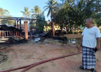 MOHAMAD Nadri Haris melihat keadaan rumahnya yang hangus dalam kebakaran di Kampung Pak Wong, Jerteh, Besut, petang tadi. - UTUSAN/WAN ZURATIKAH IFFAH WAN ZULKIFLI