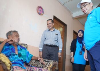 BURHANUDDIN Hilmi Mohamed@Harun (kanan) bertanyakan sesuatu kepada seorang penerima bakul makanan dan zakat  sempena Program Jejak Ramadan di Kuala Terengganu, semalam. - UTUSAN/KAMALIZA KAMARUDDIN