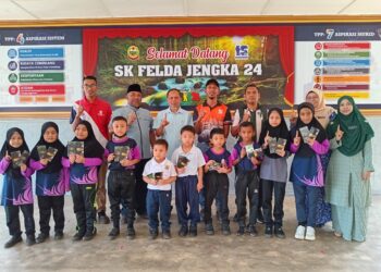 RAZAK Daud (belakang, tiga dari kiri) bergambar bersama murid yang menerima sumbangan duit raya di Sekolah Kebangsaan (SK) Felda Jengka 24 di Jerantut, Pahang.