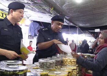 WAN MOHD. ZAHARI Wan Busu (tengah) bertemu peniaga ketika hadir pada Kempen Pencegahan Jenayah di Bazar Aidilfitri di Dataran Sekilau di Kuantan, Pahang. - FOTO/DIANA SURYA ABD WAHAB
