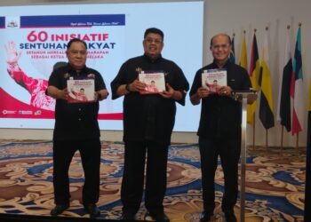 AB. RAUF Yusoh (tengah) menunjukkan buku 60 Inisiatif Sentuhan Rakyat pada Majlis Mensyukuri Setahun Pentadbiran Kerajaan Negeri di MITC, Ayer Keroh, Melaka. - UTUSAN/MUHAMMAD SHAHIZAM TAZALI