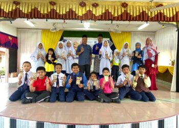 MAT ROMLI Norman (belakang, berdiri tengah) bersama murid asnaf dan anak yatim yang menerima duit raya di Felda Kota Gelanggi Dua di Jerantut, Pahang. - FOTO/HARIS FADILAH AHMAD
