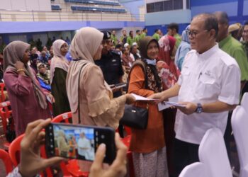 WAN ROSDY Wan Ismail (kanan) menyampaikan sumbangan Aidilfitri PKPP kepada seorang penerima di Lipis, Pahang. - UTUSAN/SALEHUDIN MAT RASAD