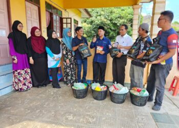 NASRUL Hadi Saiadin (empat dari kiri) memperkatakan sesuatu kepada pengamal media yang menerima sumbangan bakul makanan Madani di Kuala Terengganu, hari ini. - UTUSAN/KAMALIZA KAMARUDDIN