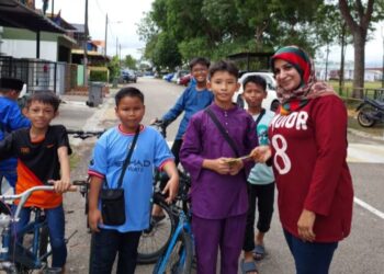 FARIDAH P. Hamsa menerima sumbangan daripada Mohd. Rayyan Ramadan di hadapan kediamannya yang musnah dalam kebakaran di Taman Scientex, Pasir Gudang.