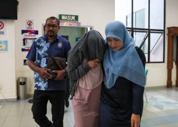 NURFIFI Amira Nawi (tengah) yang dituduh berkhalwat dibawa keluar dari Mahkamah Tinggi Syariah Terengganu,  hari ini. - UTUSAN/TENGKU DANISH BAHRI TENGKU YUSOFF