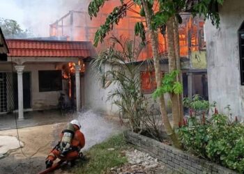 ANGGOTA bomba memadam kebakaran melibatkan dua buah rumah dihuni etnik Rohingya yang terbakar di Kampung Besut, Kemaman, hari ini. - UTUSAN/NIK NUR IZZATUL HAZWANI NIK ADNAN