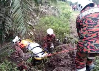 ANGGOTA bomba mengusung mayat Siti Khalijah Hassan yang maut dalam kemalangan di Kilometer 148 Jalan Jerangau-Jabor, berhampiran Air Putih, Kemaman, hari ini. - UTUSAN/NIK NUR IZZATUL HAZWANI NIK ADNAN