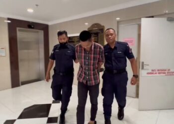 AHMAD Ridhwan Abdullah Hazam (tengah) yang dituduh mencabul kehormatan seorang wanita dibawa keluar dari Mahkamah Majistret Kuala Terengganu di Kuala Terengganu, hari ini. - UTUSAN/TENGKU DANISH BAHRI TENGKU YUSOFF