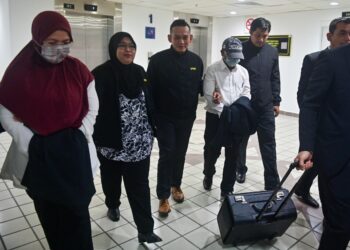 MOHAMAD Zahari Harun (empat, kiri) dan isterinya, Lydia Irmawati Mahmud (kiri) yang dituduh melakukan salah guna kuasa dan tuntutan wakalah palsu dibawa keluar dari Mahkamah Sesyen Kuala Terengganu, hari ini. - UTUSAN/PUQTRA HAIRRY ROSLI