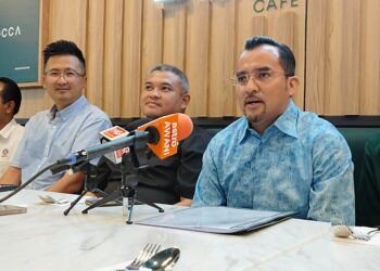 ASYRAF WAJDI Dusuki (kanan) bercakap kepada pemberita dalam sidang akhbar Majlis Perasmian LOCCA Cafe di Banda Hilir, Melaka. - UTUSAN/MUHAMMAD SHAHIZAM TAZALI