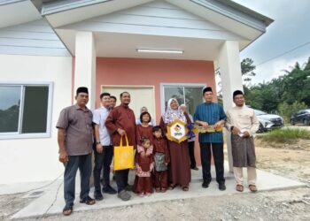HUSAM Musa bergambar kenangan bersama penerima RMR selepas Majlis Aidilfitri dan Penyerahan Kunci serta Inden Kerja RMR SPNB Cawangan Melaka di Kampung Durian Daun, Lendu, Melaka. - UTUSAN/AMRAN MULUP